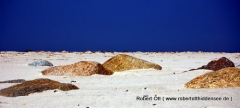 Strand verschluckt Steine